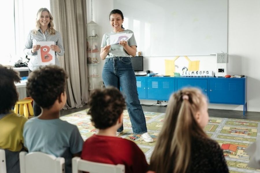 Teacher talking in front of small children. 