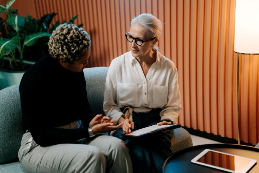 Two women talking as they review a contract.