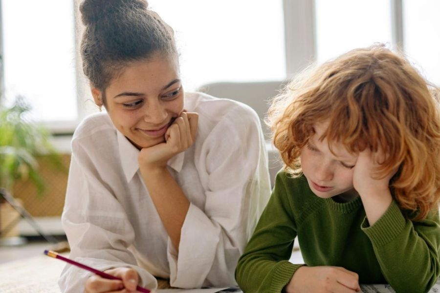 Woman helping a child with their homework.