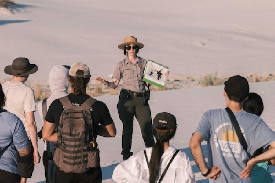 Tour guide talking to a group in the desert.